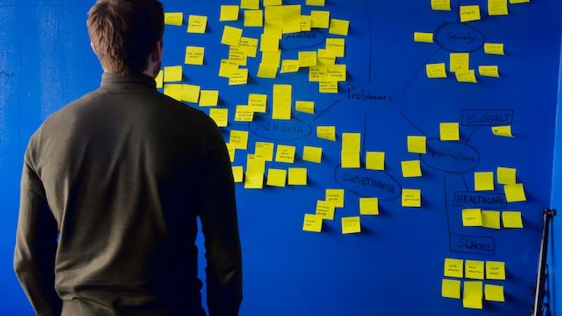man in front of a kanban board